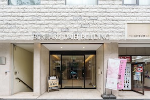 En bygningseingang med en stenfassade og et skilt, der står 'BUNRAKU DAIBUILDING'.