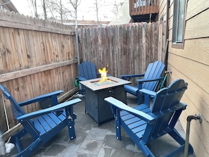A patio area with a fire pit table surrounded by four blue Adirondack chairs. - 4min walk to Downtown Flagstaff 2bd/1.5ba NEW! (Flagstaff)