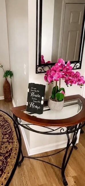 A decorative console table with a sign, a potted plant, and a mirror. - Atlanta Gem Near Stone Mountain Park Lithonia Snellville Stonecrest (Stone Mountain)