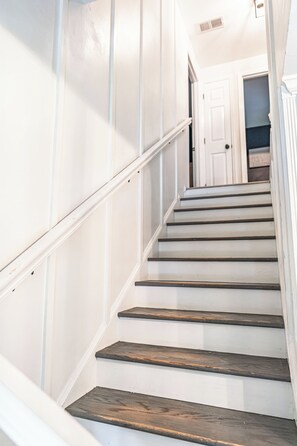 A staircase with wooden steps and white walls. - The Mad Hatter Inn - In the Village of Pinehurst! (Pinehurst)