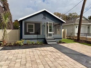 A single-story house with a garage, a front porch, and a small garden area. - Golden safari home Perfect Getaway for Relaxation (Tampa)