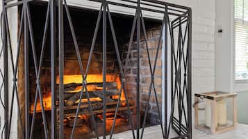 A fireplace with a metal frame and a brick interior.