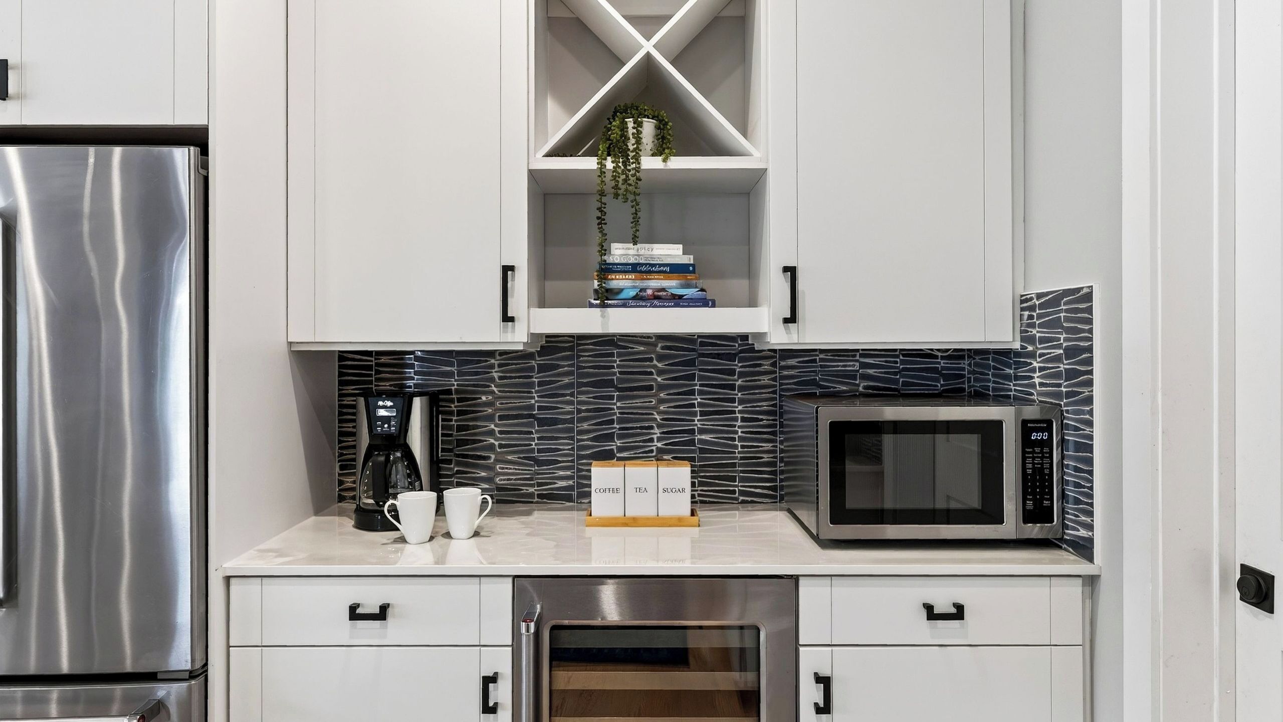 A modern kitchen with stainless steel appliances, a coffee maker, and a microwave.