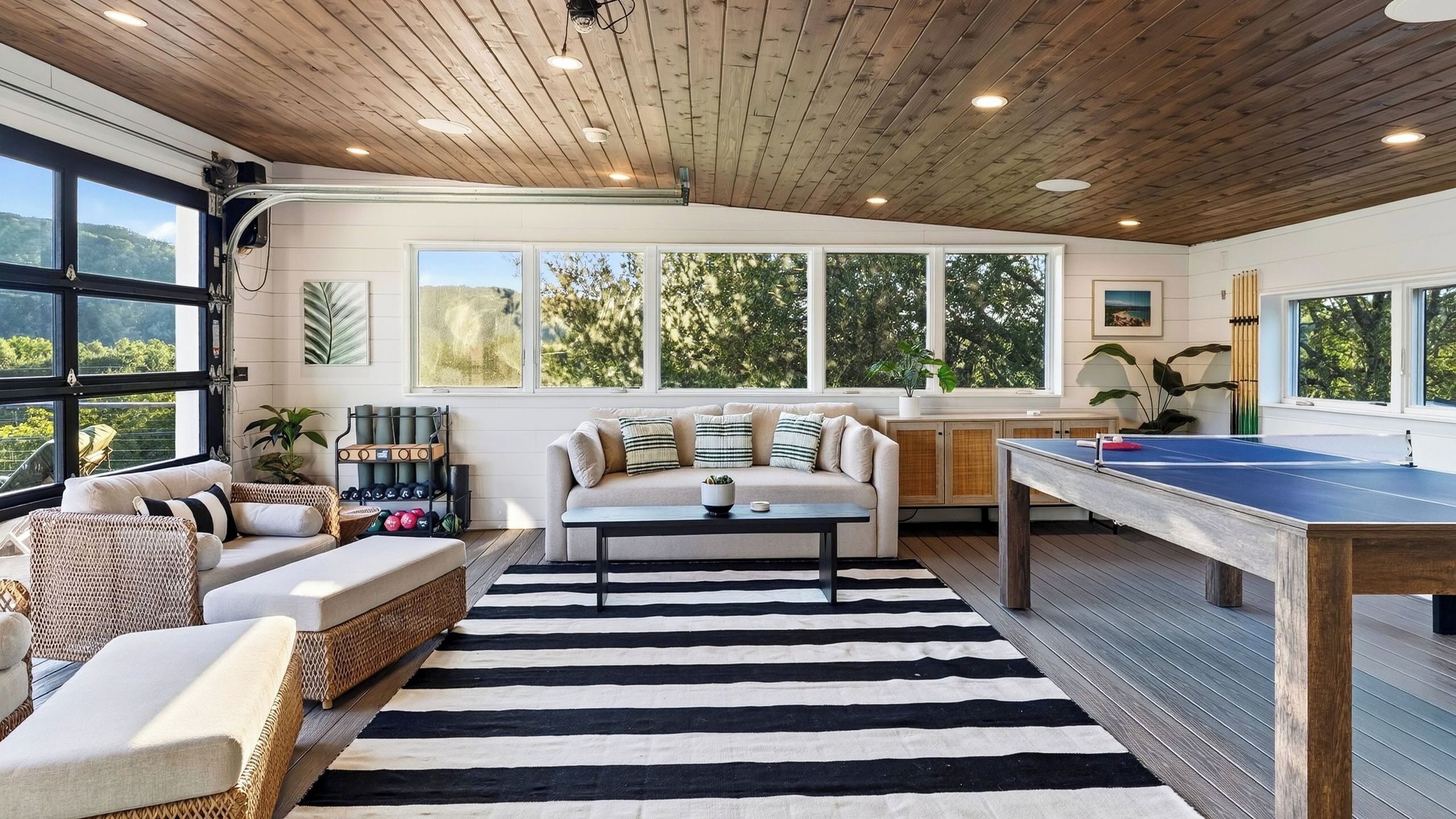 A spacious room with a ping pong table, a sofa, and a coffee table.