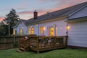 A residential house with a wooden deck, a brick chimney, and string lights. - Side Street Bungalow -Close to Town/Shopping/Tryon Equestrian Center/Restaurants (Forest City)