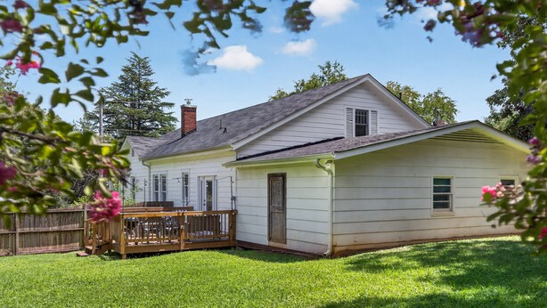 Ein zweistöckiges Haus mit Veranda und einer separaten Garage.