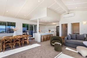 A modern interior with a dining area, kitchen, and living space. - Views on Beachman - pet friendly with lake views (Taupo)