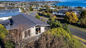 A residential area with houses, a road, and a view of the sea. - Views on Beachman - pet friendly with lake views (Taupo)