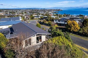 A residential area with houses, a road, and a view of the sea. - Views on Beachman - pet friendly with lake views (Taupo)