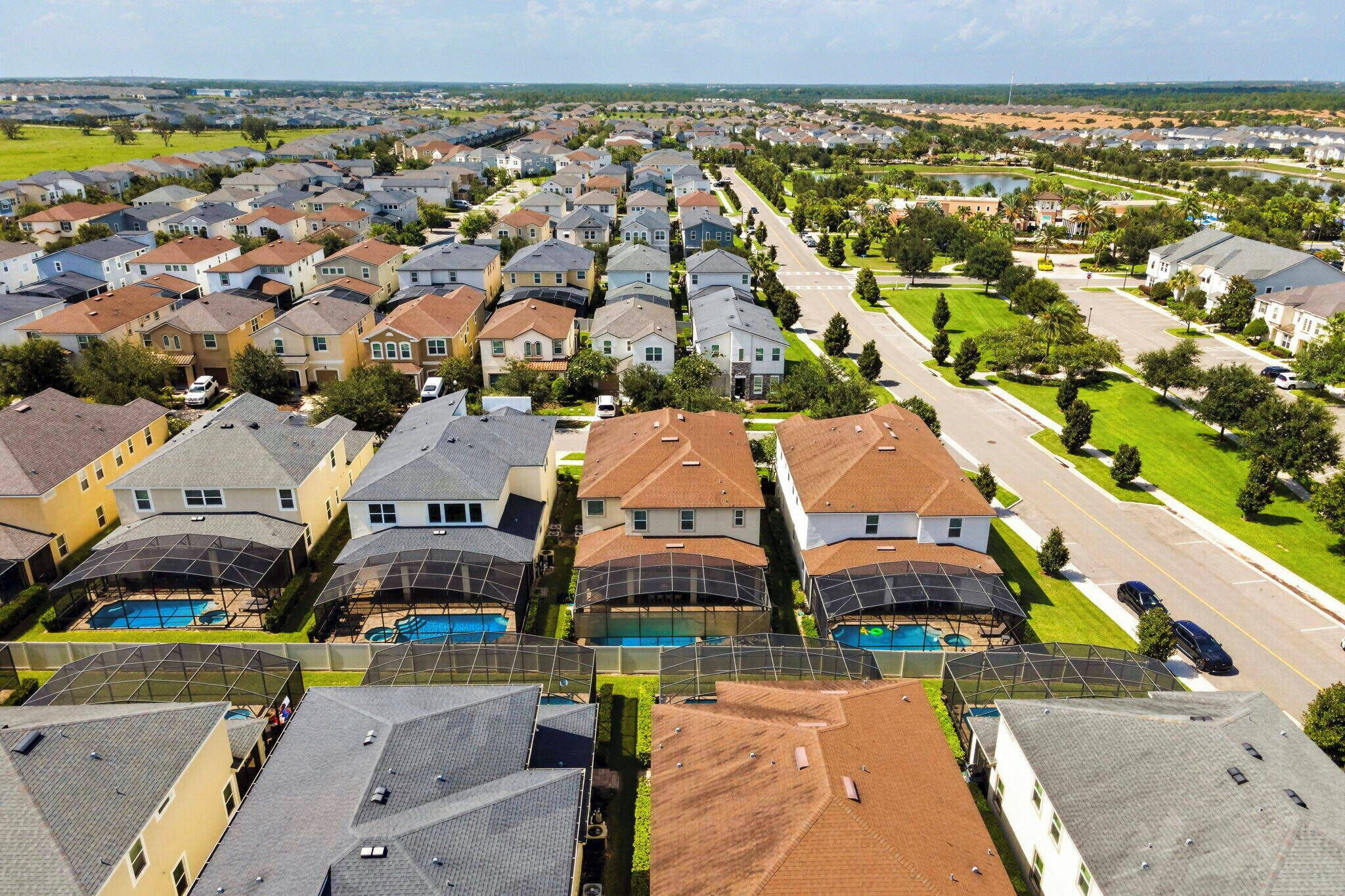 A residential area with houses, a road, and a large body of water.