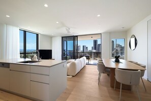 Un apartamento moderno con cocina, comedor y balcón con vistas a la ciudad.