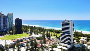 A coastal cityscape with high-rise buildings, a clear blue sky, and a beach in the distance. - Luxe Escape at Yves at Mermaid Beach (Mermaid Beach)
