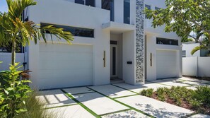 A modern two-story house with a garage, a covered entryway, and a well-maintained lawn. - Palm Perch by Avantstay Shared Pool Deck + BBQ + Skyline Balcony Walk to Las Olas (Fort Lauderdale)