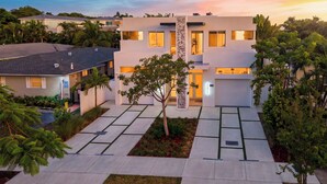A modern two-story house with a driveway, a tree, and a well-maintained lawn. - Palm Perch by Avantstay Shared Pool Deck + BBQ + Skyline Balcony Walk to Las Olas (Fort Lauderdale)