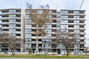 A multi-story residential building with balconies, a flat facade, and a central entrance. - Inner North 1BR Near Braddon & Dickson (Lyneham)