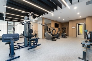 A modern gym with various exercise equipment, including a squat rack and treadmills.
