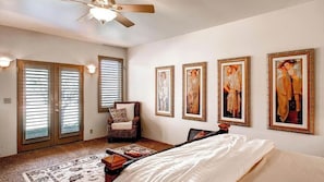 A bedroom with a bed, a chair, a ceiling fan, and four framed paintings on the wall. - Solitude I by Avantstay Vineyard Views + Jetted Tub Paso Wine Country (Paso Robles)