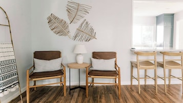A room with two chairs, a small table, and a decorative wall piece.