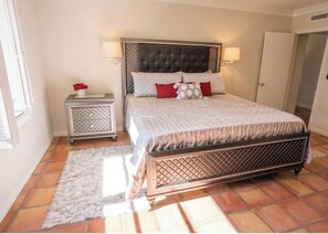 A bedroom with a large bed, two bedside tables, a nightstand, a rug, and a door. -  New Property! The Hidden Catch.. 2-bdr house on the water and great for fishing (Lauderdale-by-the-Sea)