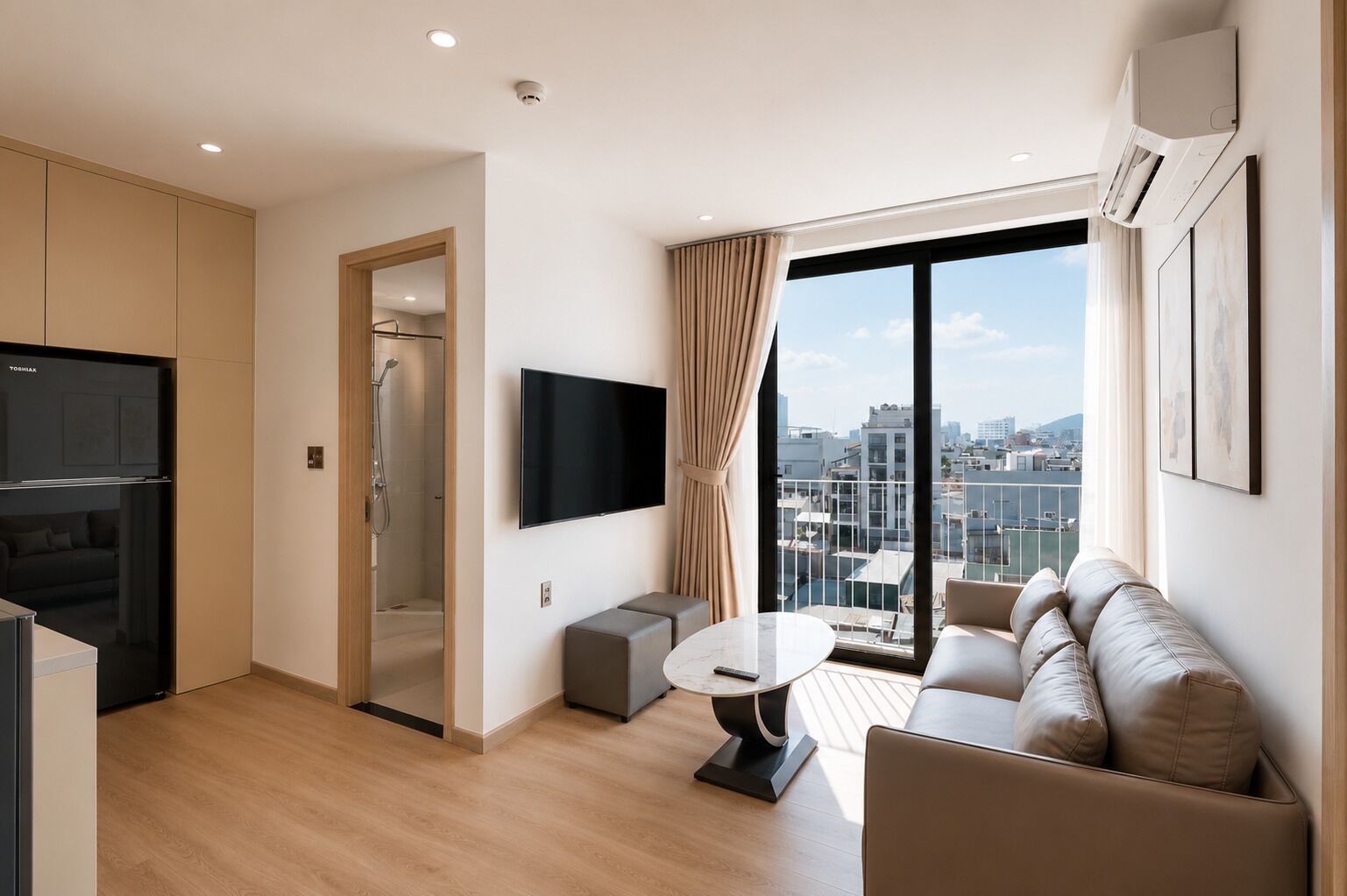 A modern living room with a sofa, a TV, a small table, and a city view through large windows.