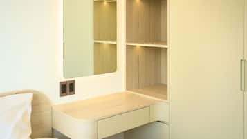 Un baño moderno con lavamanos integrado, espejo y estantería de madera.