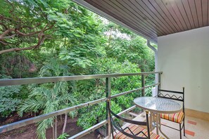 A balcony with a metal railing, a round table, and a chair with striped cushions. - The 1 Bedroom "Five" Garden view and Olympic Pool (Muang Pattaya)
