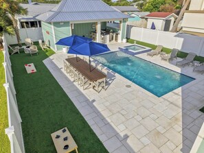 A backyard with a swimming pool, a barbecue area, and a covered seating area. - Casa Elcoqui | LUX Gulf Views, Pool + Spa, Sleeps 16 (Panama City Beach)