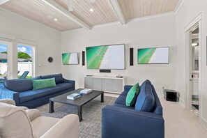 A modern living room with a sofa, coffee table, and artwork on the wall. - Casa Elcoqui | LUX Gulf Views, Pool + Spa, Sleeps 16 (Panama City Beach)