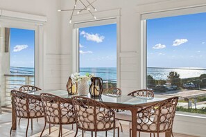 A dining area with a glass table and wicker chairs, overlooking a scenic view. - Casa Elcoqui | LUX Gulf Views, Pool + Spa, Sleeps 16 (Panama City Beach)