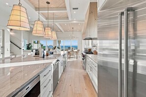 A modern kitchen with a large island, stainless steel appliances, and pendant lighting. - Casa Elcoqui | LUX Gulf Views, Pool + Spa, Sleeps 16 (Panama City Beach)