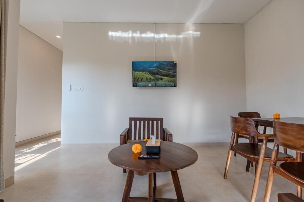 Un comedor moderno con una mesa redonda, sillas de madera y un cuadro en la pared.