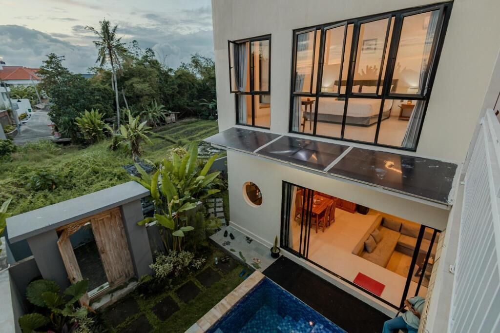 Un bâtiment moderne à deux étages doté d’une piscine, d’un espace extérieur aménagé et offrant une vue sur la verdure environnante.