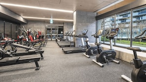 A gym with treadmills, stationary bikes, and weight machines. - Upper West Side by Ready Set Stay (Melbourne)