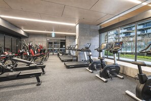A gym with treadmills, stationary bikes, and weight machines. - Upper West Side by Ready Set Stay (Melbourne)