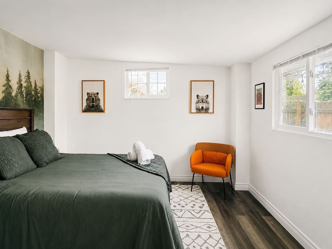 Une chambre à coucher avec un lit, une chaise et des tableaux encadrés accrochés au mur.