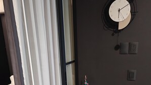 Una habitación con una cama, un escritorio con una bandera, un reloj y una silla.
