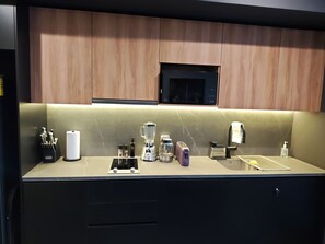 A modern kitchen with wooden cabinets, a microwave, a blender, a toaster, and a sink. - Balcony with a view of the Monument to the Revolution, Rooftop, and Gym (Ciudad de México)