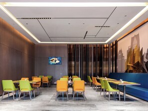 Un restaurante moderno con techo alto, iluminación empotrada y un mural con vista a la ciudad.