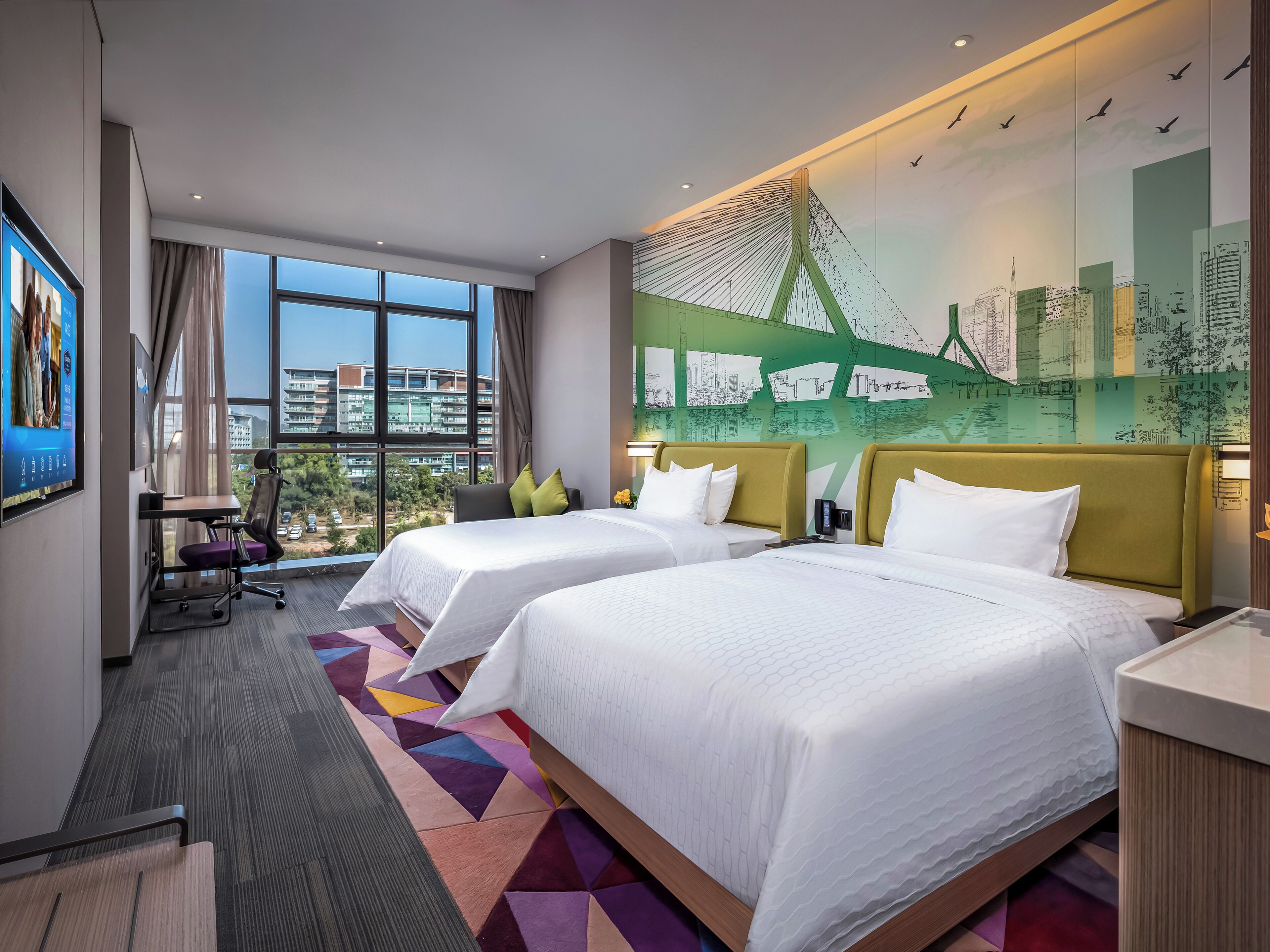 A hotel room with two beds, a desk, a chair, and a large window with a city view.