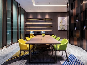 A modern meeting room with a long table, yellow chairs, and a patterned carpet. - Hampton by Hilton panyu avenue (Guangzhou)