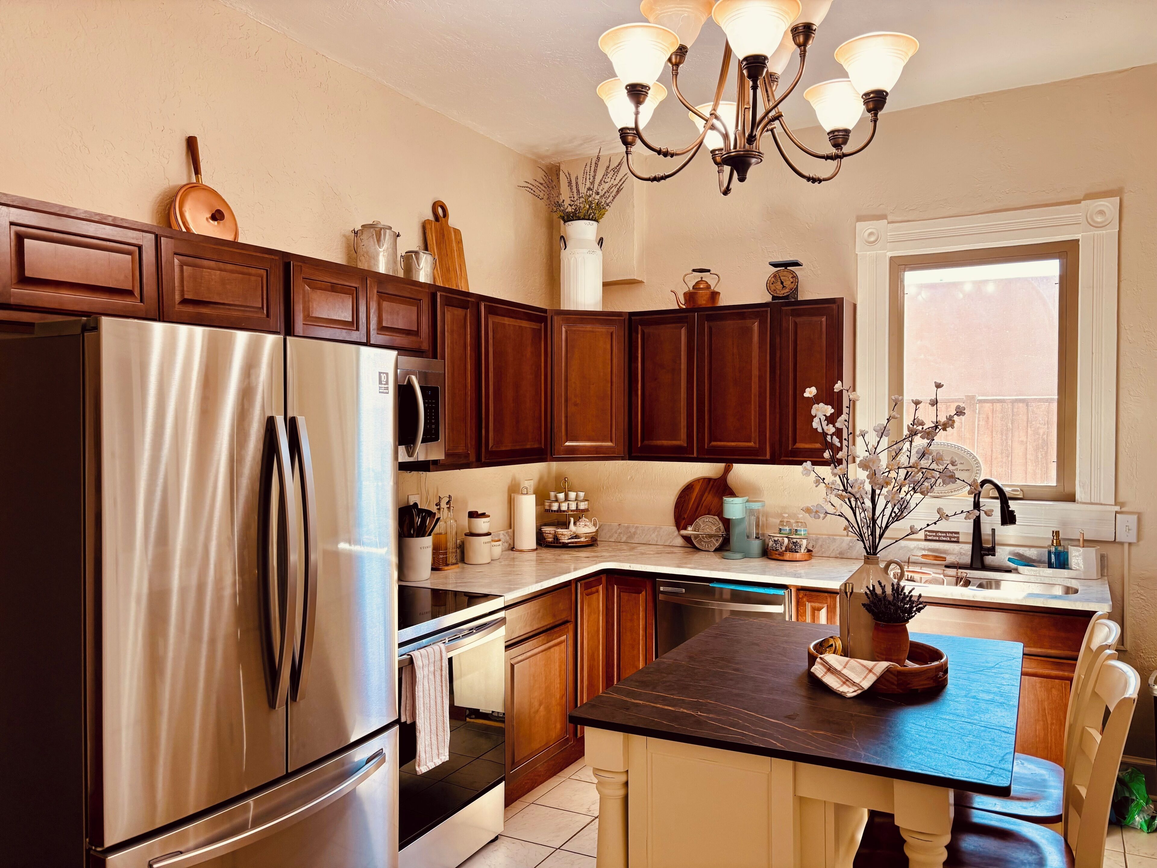 A modern kitchen with stainless steel appliances, wooden cabinets, and a central island with seating.