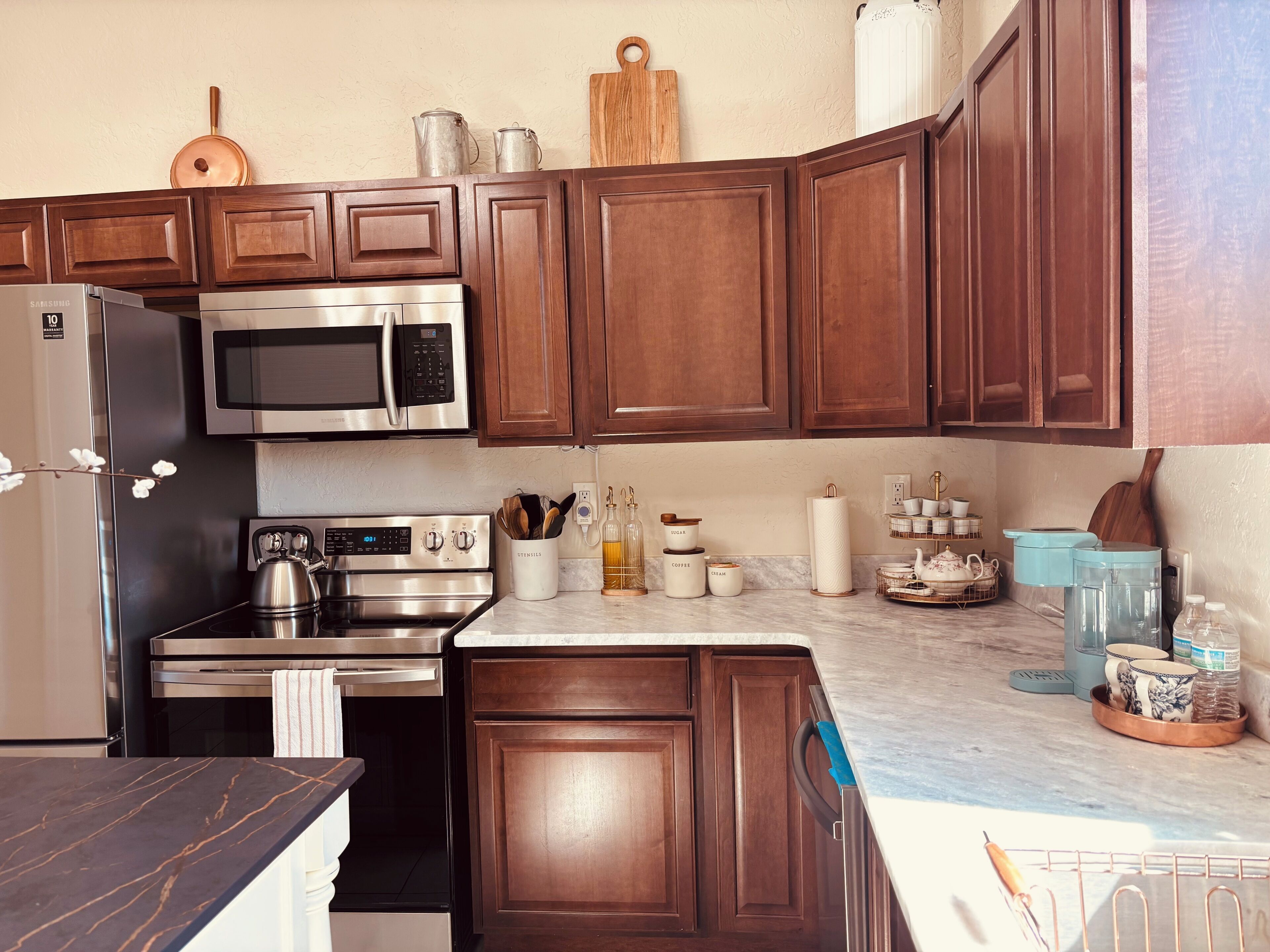 Una cocina moderna con armarios de madera, electrodomésticos de acero inoxidable y encimera de mármol.