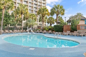 A hotel pool area with a clear blue pool, lounge chairs, and palm trees. - Beachfront Condo|Private Pool, Oceanfront Balcony (North Myrtle Beach)