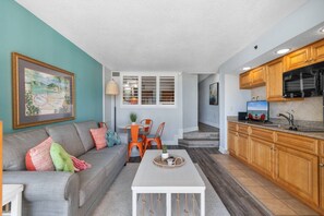 A compact living space with a sofa, dining table, and kitchen area. - Beachfront Condo|Private Pool, Oceanfront Balcony (North Myrtle Beach)