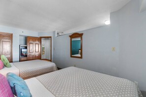 A hotel room with two beds, a mirror, a door leading to a bathroom, and a small kitchenette. - Beachfront Condo|Private Pool, Oceanfront Balcony (North Myrtle Beach)