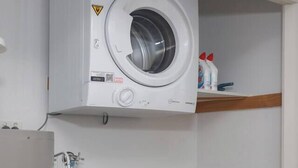 A laundry area with a top-loading washing machine and a front-loading washing machine. - Laidback Lygon A Two Storey Inner City Oasis (Brunswick East)
