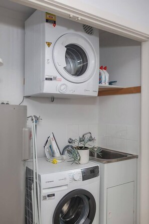 Ein Waschbereich mit einer Waschmaschine mit Oberlader und einer Waschmaschine mit Frontlader.