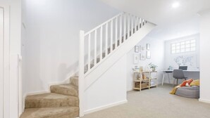 A staircase leading to a living area with a desk, bookshelf, and a bean bag. - Laidback Lygon A Two Storey Inner City Oasis (Brunswick East)