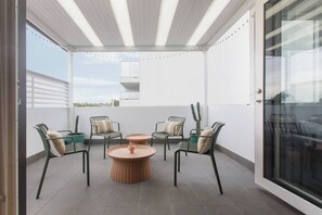 A covered outdoor patio with four chairs, a round table, and a cactus plant. - Laidback Lygon A Two Storey Inner City Oasis (Brunswick East)