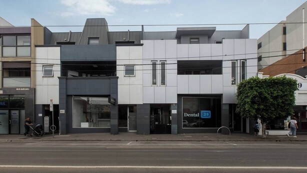 A modern building with a dental clinic on the ground floor, featuring a large glass entrance and a sign with 'Dental ED'. - Laidback Lygon A Two Storey Inner City Oasis (Brunswick East)